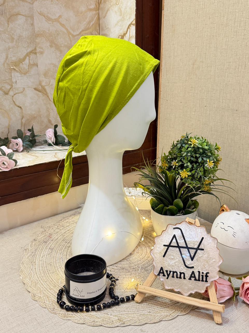 Lime green plain tie-back hijab underscarf cap in soft stretch fabric displayed on mannequin side view