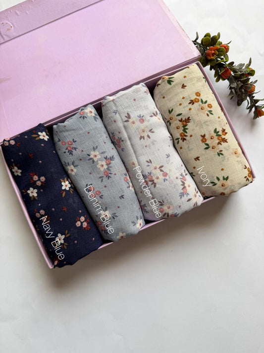 Malaysian printed lawn hijabs in Navy Blue, Denim Blue, Powder Blue and Ivory stacked in a display box. Soft breathable lawn fabric for daily wear.