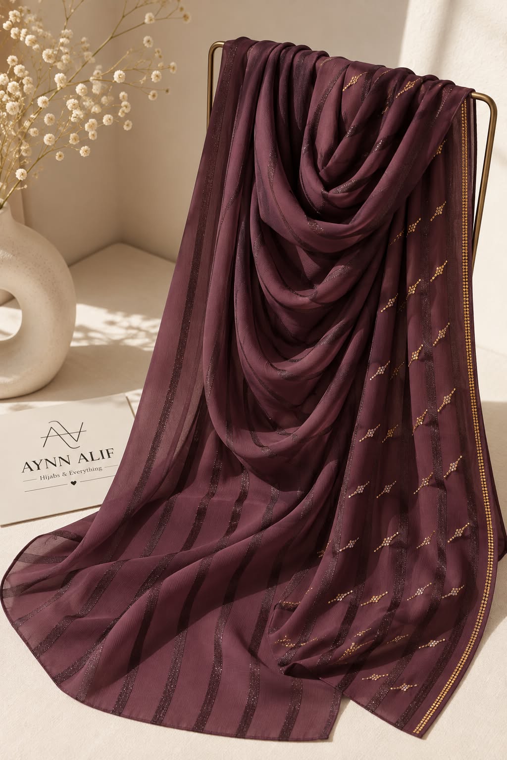 Maroon crinkle chiffon georgette hijab with satin stripes and delicate stone-studded detailing by Aynn Alif.