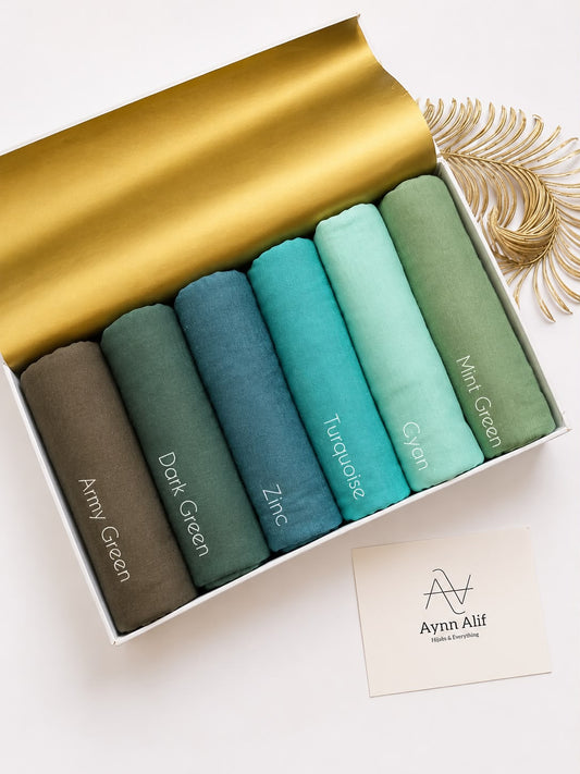 Plain jersey hijabs in shades of green displayed in minimal aesthetic setup