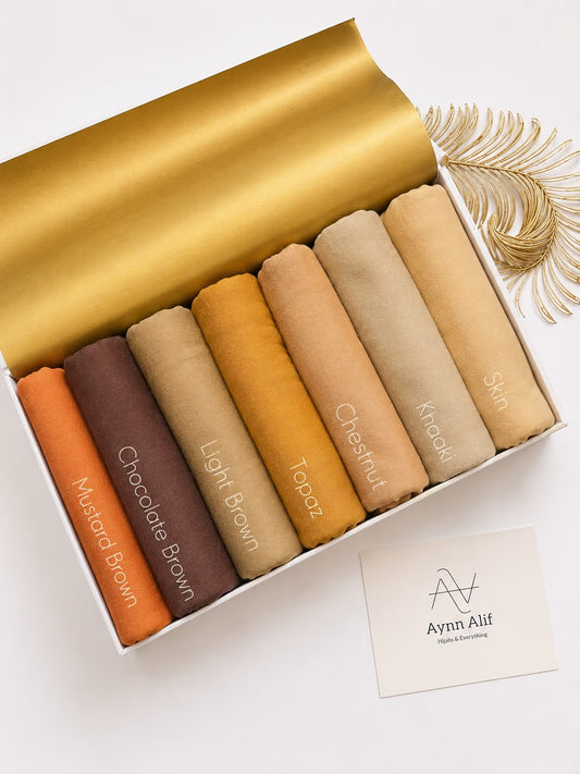 Plain jersey hijabs in warm neutral shades like rust, brown and beige neatly arranged