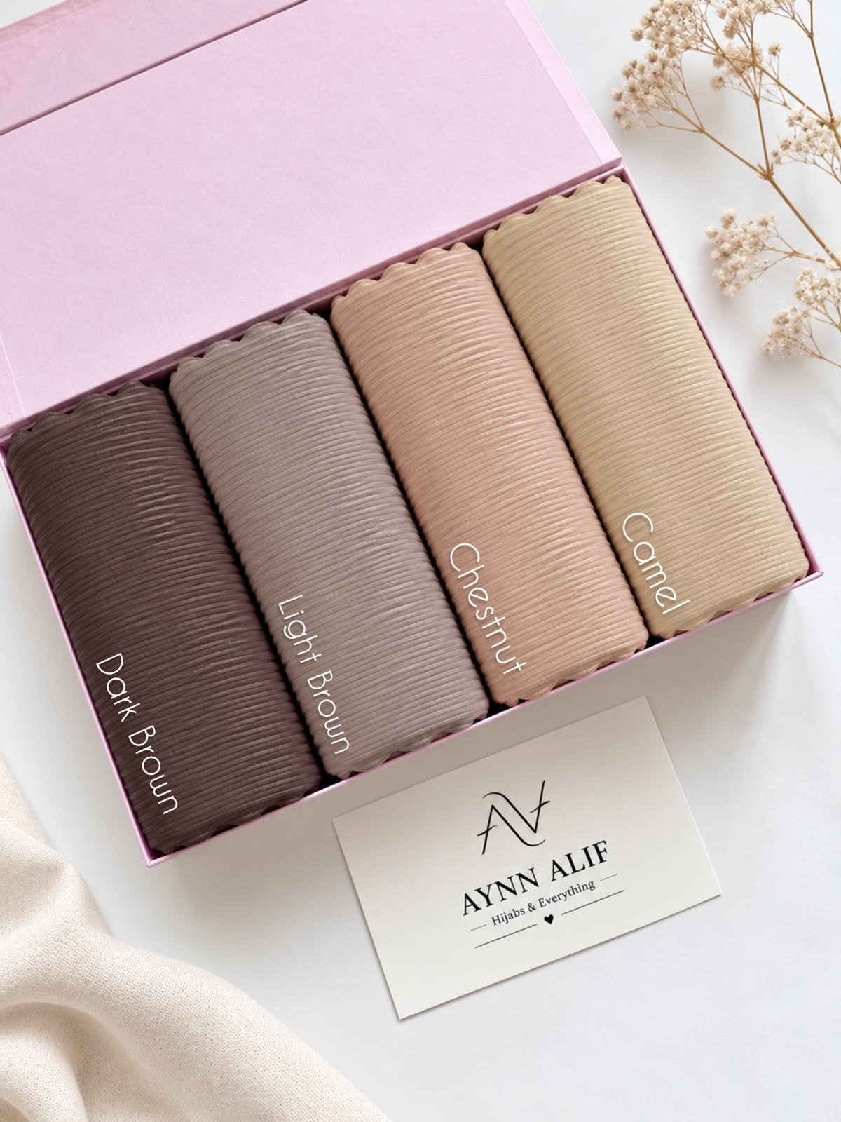 Aynn Alif ribbed jersey hijabs in Dark Brown, Light Brown, Chestnut and Camel arranged in a pink presentation box.