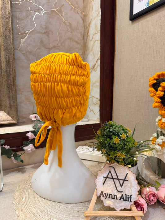 Yellow ruched tie back hijab cap made from soft breathable jersey with full head coverage and adjustable tie-back by Aynn Alif.