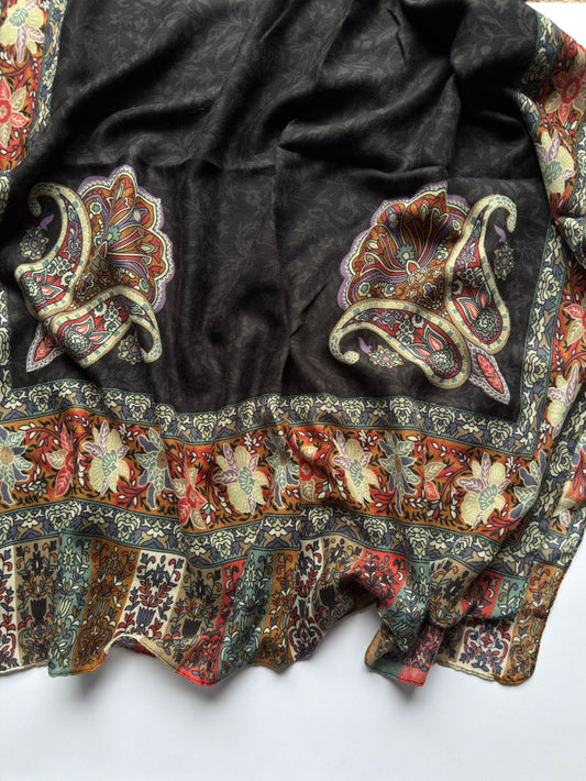 Decorative black fabric with intricate floral patterns on a white background