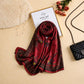 
Rich burgundy printed silk scarf with delicate floral motifs and an elegant patterned border by Aynn Alif