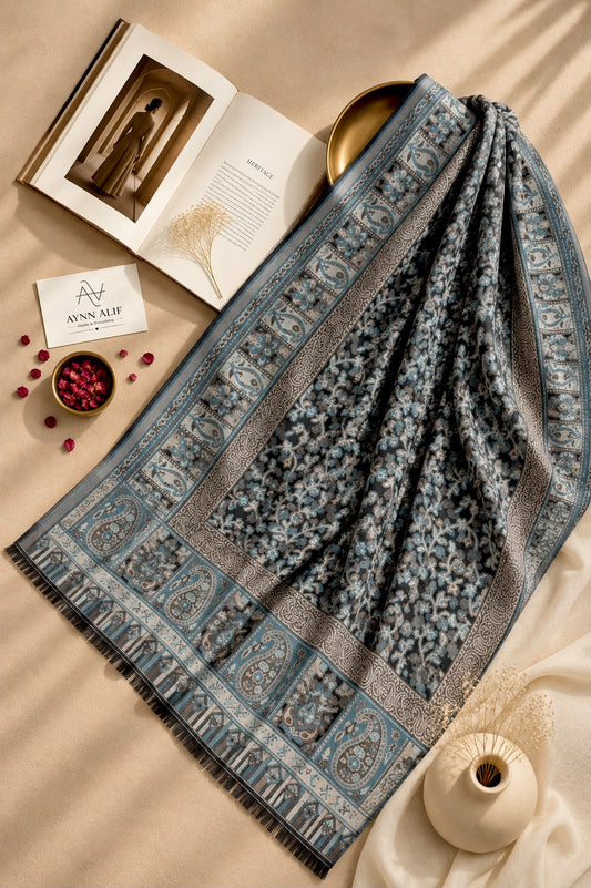 Aynn Alif Kashmiri Kani mini shawl in charcoal black, dusty blue and taupe, featuring intricate floral motifs, paisley borders, ornamental patterns and dark fringe detailing.