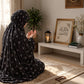 Aynn Alif black namaz chaadar featuring a delicate white mini floral print, styled on a prayer mat in an elegant prayer setting.
