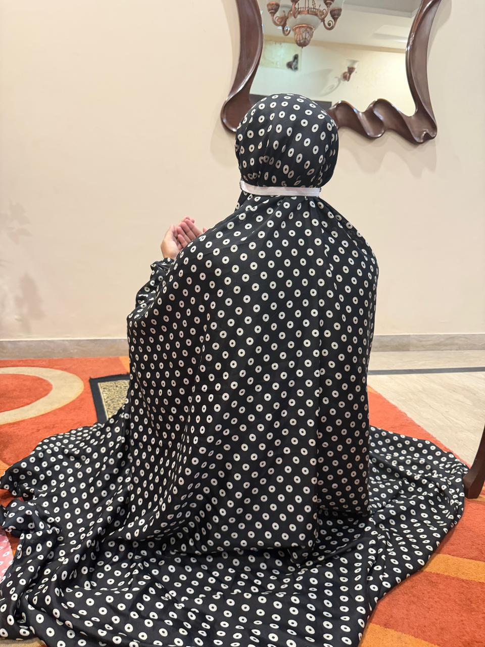 Black namaz chaadar with white rings by Aynn Alif Pakistan featuring elastic sleeves, elastic headband, wudu-friendly design, and full coverage prayer wear for women.