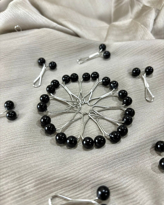 Black pearl loop pin for hijab styling featuring glossy black beads and silver glider design, snag-free scarf accessory with secure hold.