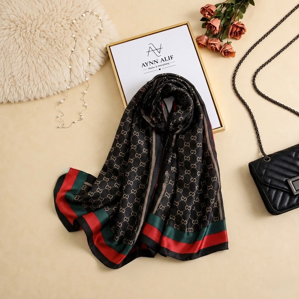 Black printed silk scarf with chain-inspired pattern and red and green contrast striped pallu ends by Aynn Alif