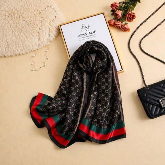 Black printed silk scarf with chain-inspired pattern and red and green contrast striped pallu ends by Aynn Alif