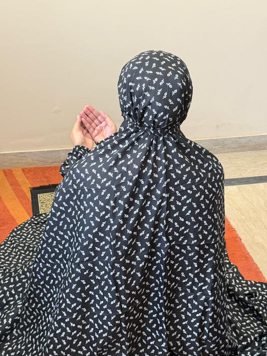 Black and white floral namaz chaadar for women by Aynn Alif Pakistan with elastic sleeves, elastic headband, wudu-friendly design, and full coverage prayer wear.