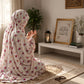 Aynn Alif blush ivory namaz chaadar featuring delicate pink, magenta and yellow floral prints, styled for prayer on a patterned prayer mat.