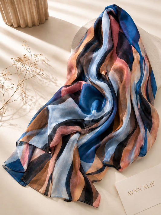 Aynn Alif extra large printed modal lawn hijab featuring an abstract wave pattern in blue, powder blue, black, dull coral pink and soft peach tones.