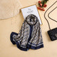 Navy blue and ivory printed silk scarf with repeating signature-inspired pattern by Aynn Alif