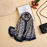 Navy blue and ivory printed silk scarf with repeating signature-inspired pattern by Aynn Alif