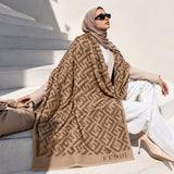 Camel beige geometric monogram-inspired pashmina wrap with warm brown pattern and coordinating border styled as an elegant winter layer.