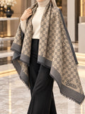 Camel beige and charcoal monogram-inspired pashmina wrap with grey border and fringed edges styled as an elegant winter layer.