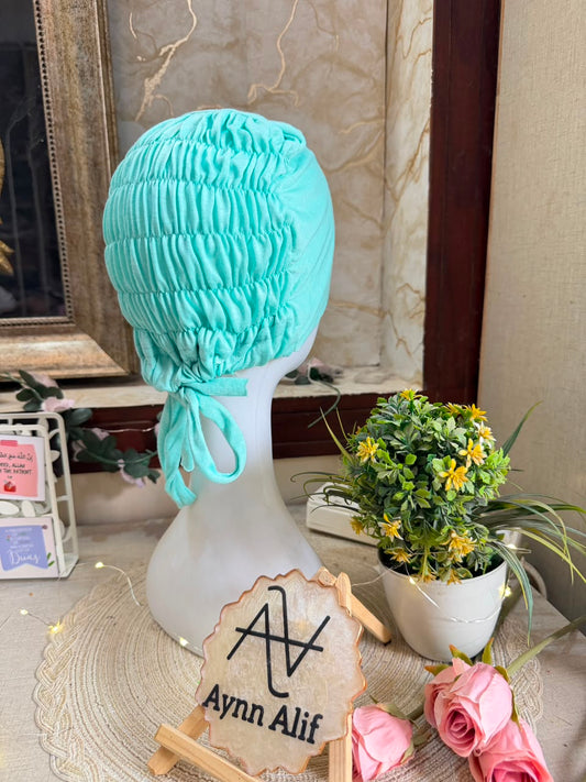 Cyan ruched tie back hijab cap made from soft breathable jersey with full head coverage and adjustable tie-back by Aynn Alif.