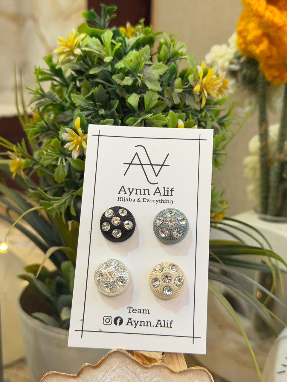 Black, grey, white and beige stone studded hijab magnets displayed on Aynn Alif card