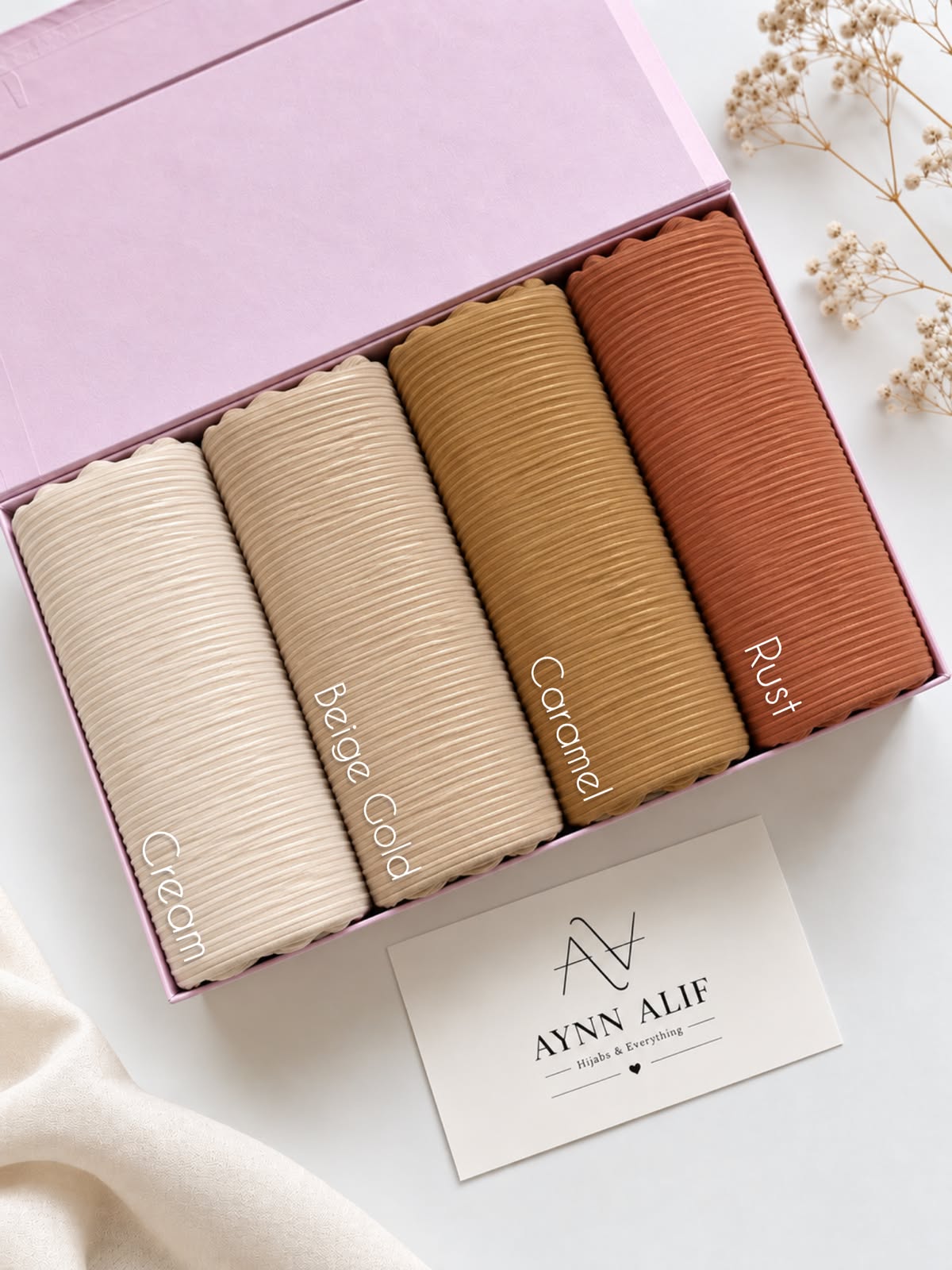 Aynn Alif ribbed jersey hijabs in Cream, Beige Gold, Caramel and Rust arranged in a pink presentation box