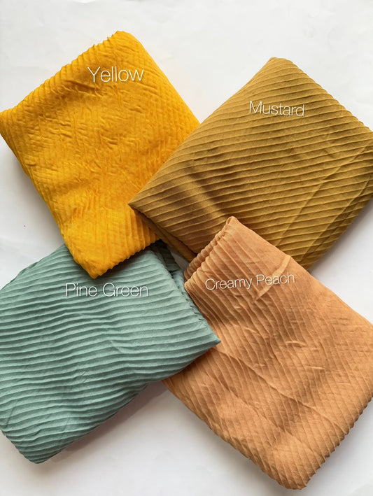 Bubble pleated lawn hijabs by Aynn Alif Pakistan in yellow, mustard, pine green and creamy peach shades with lightweight breathable fabric for everyday modest wear.