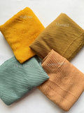 Bubble pleated lawn hijabs by Aynn Alif Pakistan in yellow, mustard, pine green and creamy peach shades with lightweight breathable fabric for everyday modest wear.