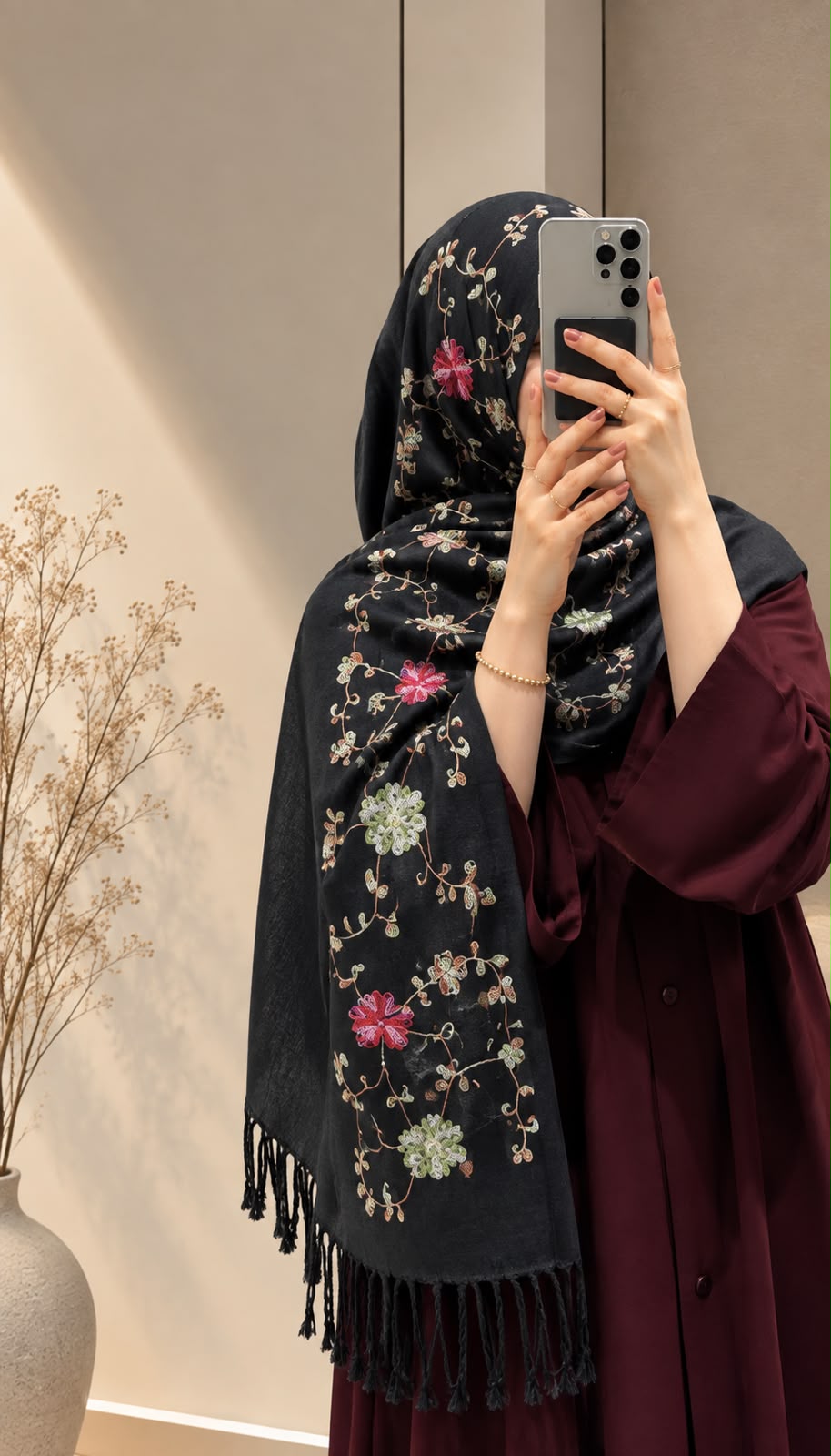 Jet black cashmere embroidered hijab featuring colourful floral motifs, delicate sequin embellishments, and matching black fringed edges by Aynn Alif.