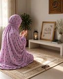 Lilac pink namaz chaadar with a delicate multicolour floral print, styled on a prayer mat in a serene prayer setting by Aynn Alif.