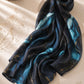 Aynn Alif extra large printed modal lawn hijab featuring a black base with aqua blue marble design and gold accents, styled in a luxury flat lay.