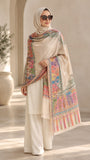 Beige printed pashmina shawl with multicolour floral and ornamental borders in coral pink, peach, turquoise, purple and mustard, styled with a cream outfit by Aynn Alif