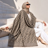 Mushroom taupe pashmina wrap with contrasting geometric pattern, tonal border and fringed edges styled elegantly over a winter outfit.