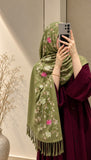 Olive green cashmere embroidered hijab featuring pink and ivory floral embroidery, delicate sequin embellishments, and matching fringed edges by Aynn Alif.