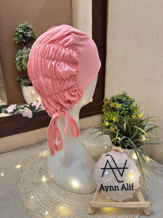 Peachish Pink ruched tie back hijab cap made from soft breathable jersey with full head coverage and adjustable tie-back by Aynn Alif.