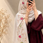 Pearl white cashmere embroidered hijab featuring pink and green floral motifs, delicate sequin embellishments, and matching white fringed edges by Aynn Alif.