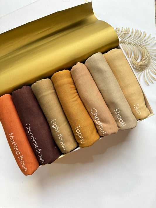 Plain jersey hijabs in warm neutral shades like rust, brown and beige neatly arranged