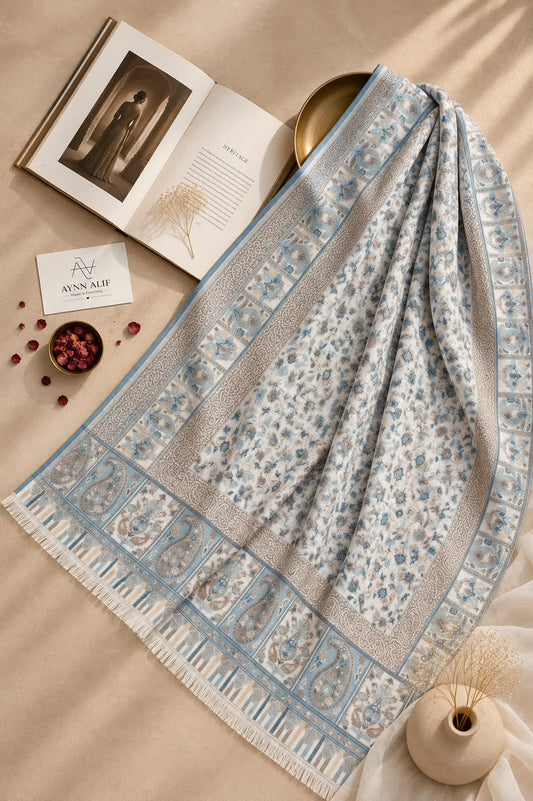 Aynn Alif Kashmiri Kani mini shawl in powder blue and ivory, featuring delicate floral motifs, intricate paisley patterns, ornamental borders, and ivory fringe detailing.