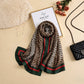 Leopard print silk scarf in beige and brown with emerald green and deep red contrast detailing by Aynn Alif